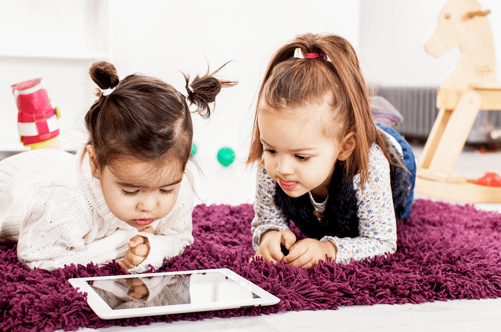 Two little girls watching a movie on an tablet